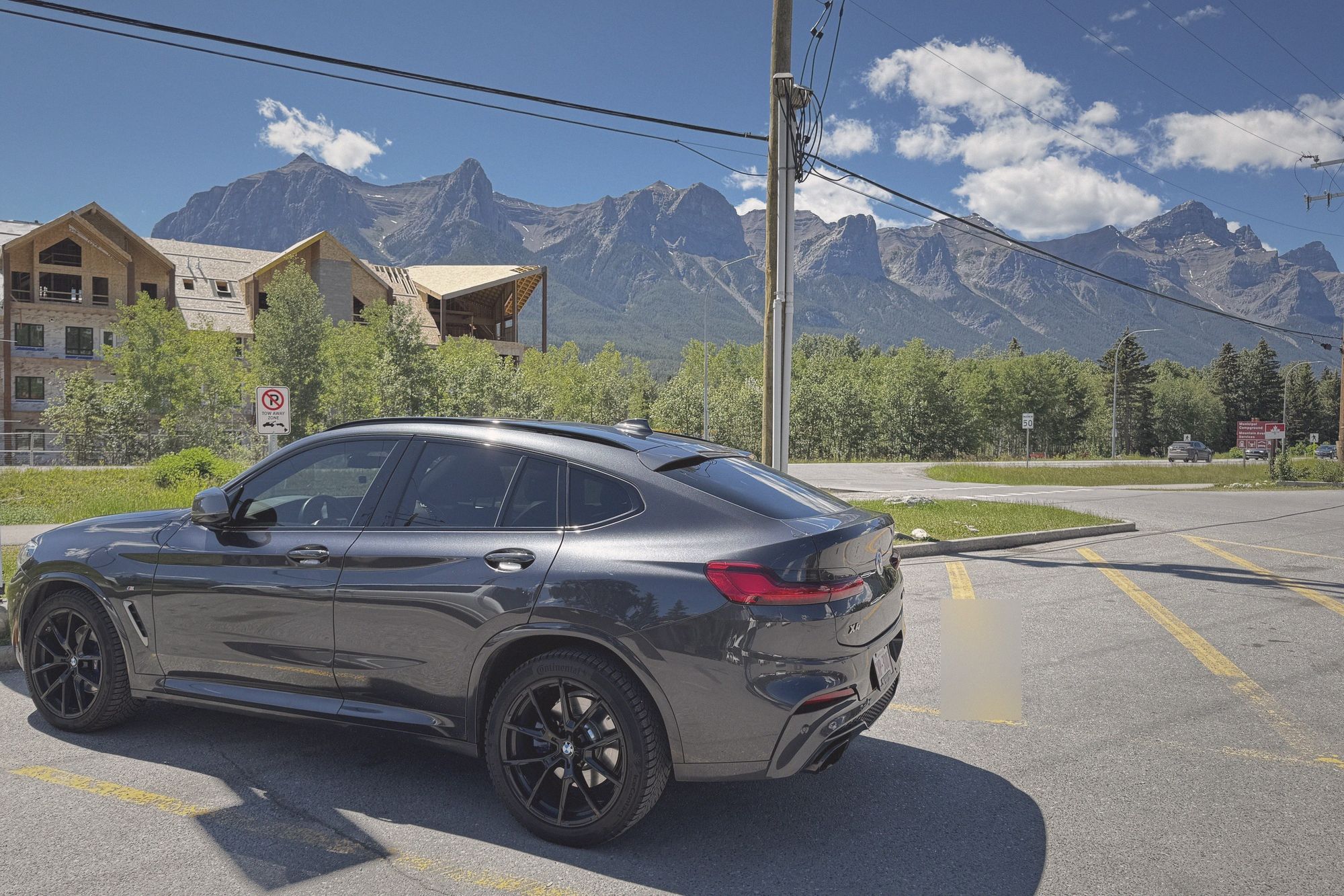 Grey BMW X4 M40i under the Three Sisters on a bright summer day